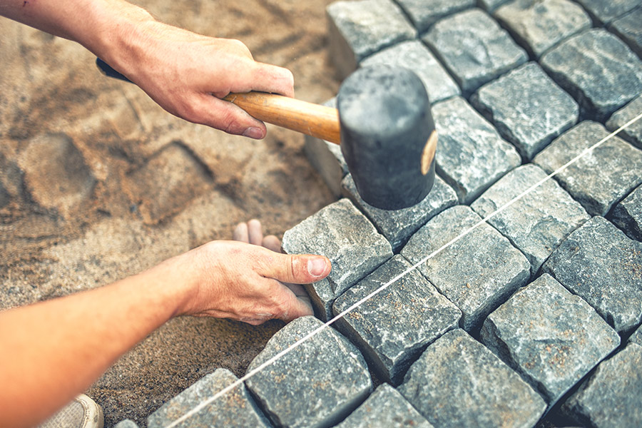 contractor hands close up with hammer installing concrete patio muskogee ok